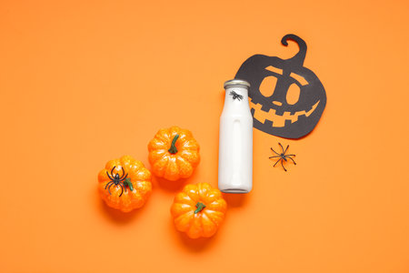 Composition with bottle of milk and pumpkins on orange backgroundの写真素材