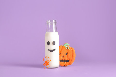 Bottle of milk, spider and tasty cookie for Halloween on purple backgroundの写真素材