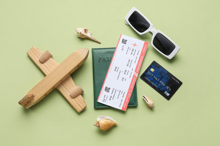 Composition with ticket, credit card, wooden plane and sunglasses on green backgroundの写真素材