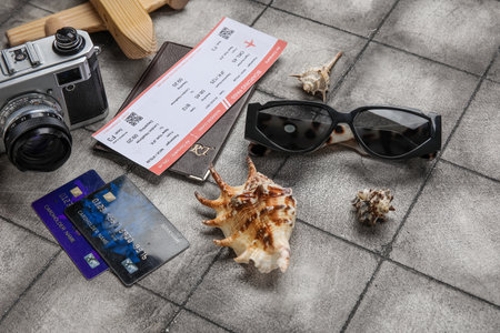 Composition with credit cards, ticket, sunglasses and seashells on grunge tile backgroundの写真素材