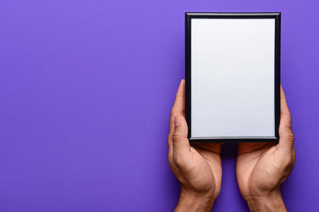 Man holding blank photo frame on purple backgroundの写真素材