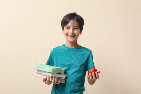 Little boy with lunchbox and apple on beige backgroundの写真素材