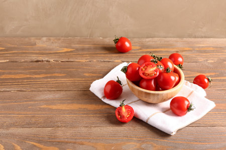 Bowl with fresh cherry tomatoes on wooden tableの写真素材