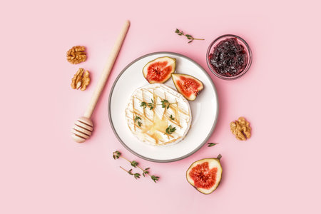 Plate of tasty baked Camembert cheese on pink backgroundの写真素材