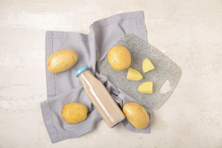 Bottle of tasty potato milk on light backgroundの写真素材