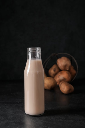 Bottle of tasty potato milk on black backgroundの写真素材