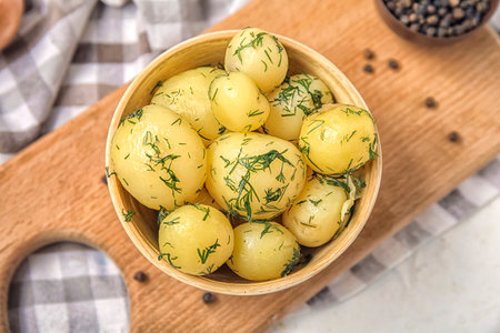 Bowl with boiled baby potatoes on light backgroundの写真素材