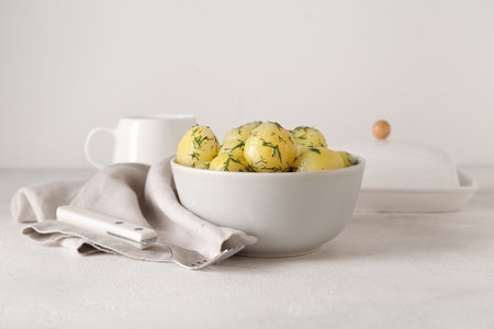 Bowl with boiled baby potatoes on light backgroundの写真素材