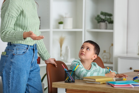 Cute little boy doing lessons with his mother at homeの写真素材