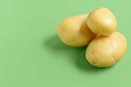 Raw potatoes on green backgroundの写真素材