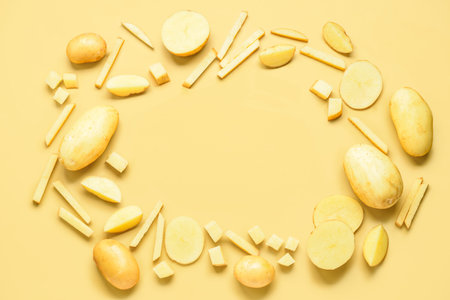 Frame made of raw potatoes on yellow background