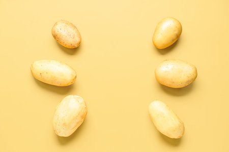 Raw potatoes on yellow backgroundの写真素材