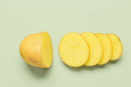 Raw cut potato on green backgroundの写真素材