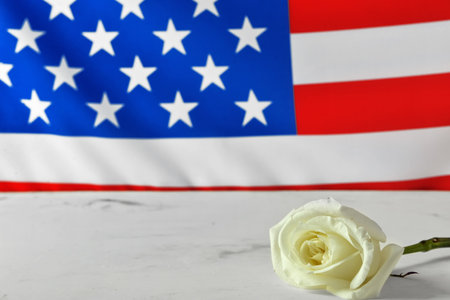 Rose flower on table against USA flag. National Day of Prayer and Remembrance for the Victims of the Terrorist Attacksの写真素材