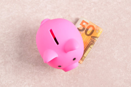Pink piggy bank with euro banknotes on grunge pink backgroundの写真素材
