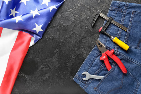 Composition with jeans, different tools and USA flag on black background. labor day celebrationの写真素材