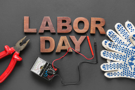 Composition with different tools, gloves and text LABOR DAY on black backgroundの写真素材