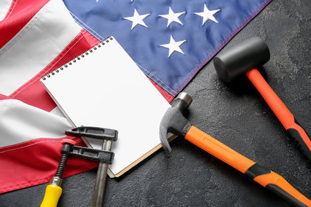 Composition with different tools, notebook and USA flag on black background. labor day celebrationの写真素材