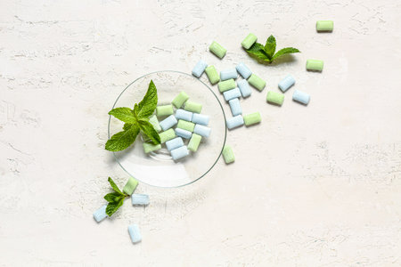 Bowl of fresh chewing gums with mint on white backgroundの写真素材