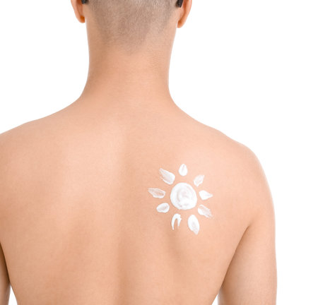 Young man with sun made of protection cream on his body against white background, back view