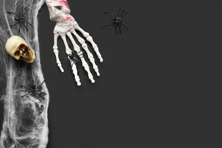 Skeleton hand, skull, web and spiders for Halloween celebration on dark backgroundの写真素材