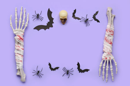 Frame made of skeleton hands, skull, paper bats and spiders for Halloween celebration on purple...