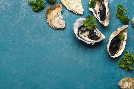 Tasty oysters with black caviar on blue background