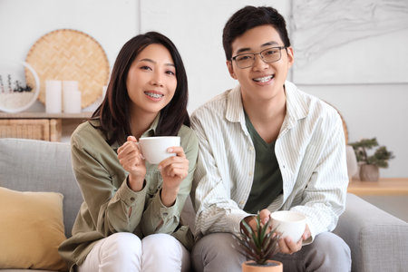Young Asian friends drinking coffee at homeの写真素材