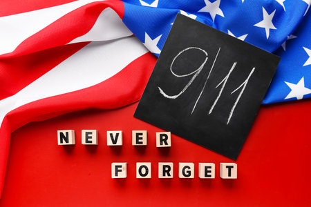 USA flag and card with date of National Day of Prayer and Remembrance for the Victims of the Terrorist Attacks on red backgroundの写真素材