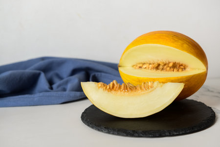 Slate board with tasty ripe melon on tableの写真素材