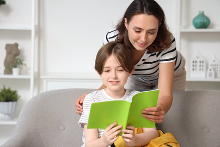 Mother helping her little son with homework at homeの写真素材