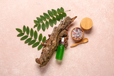 Bottle and jar of cosmetic products with sea salt on pink backgroundの写真素材