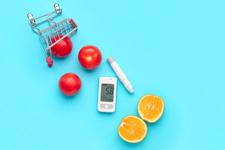 Glucometer with food, lancet pen and shopping cart on blue background. Diabetes concept