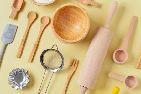 Set of baking utensils and ingredients on beige background