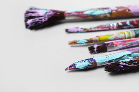 Dirty paint brushes on white background