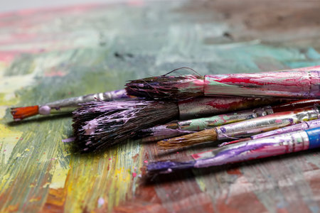 Dirty paint brushes on colorful background