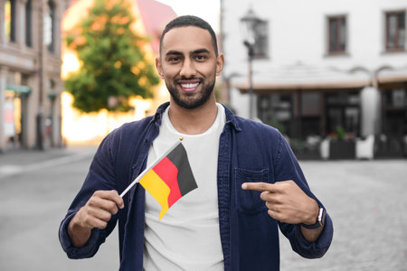 Young man with flag of Germany on city streetの写真素材