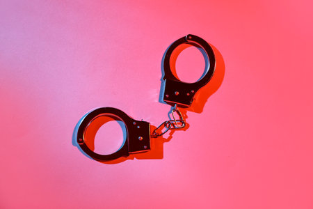 Handcuffs from sex shop on red backgroundの写真素材