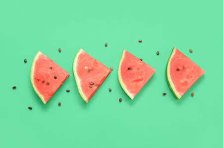 Composition with pieces of ripe fresh watermelon and seeds on green background