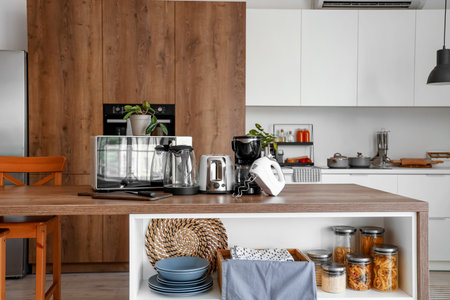Interior of light kitchen with modern appliances on wooden tableの写真素材