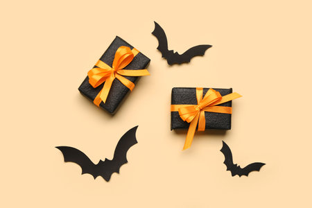 Paper bats for Halloween party and gift boxes on orange backgroundの写真素材