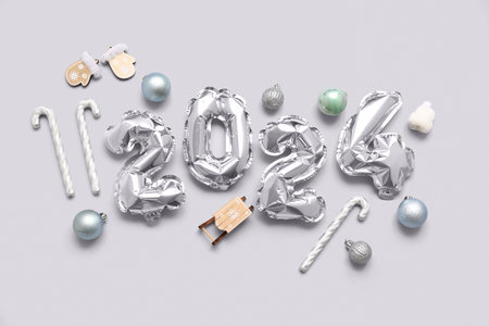 Figure 2024 made of balloons with Christmas decorations on gray backgroundの写真素材