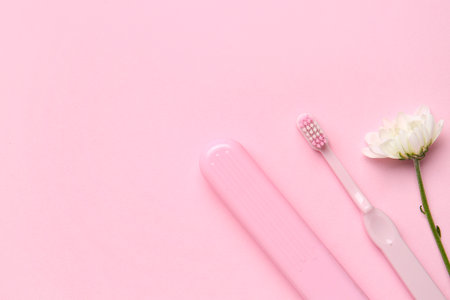 Toothbrush, case and chamomile flower on pink backgroundの写真素材