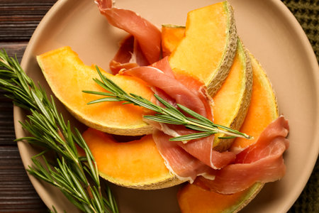 Plate with tasty melon, prosciutto and rosemary, closeupの写真素材
