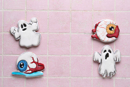 Different tasty cookies for Halloween celebration on pink tile backgroundの写真素材