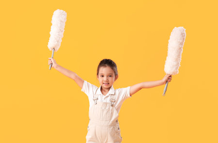 Cute little girl with pp-dusters on yellow background