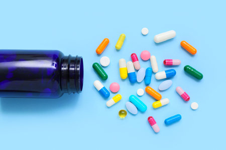 Composition with colorful pills and bottle on color background, closeupの写真素材