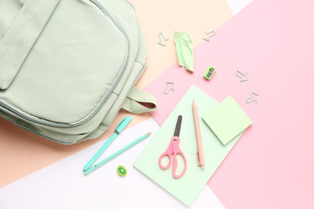 Stylish school backpack with different stationery supplies on colorful backgroundの写真素材