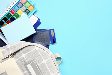Stylish school backpack with different stationery supplies on blue backgroundの写真素材