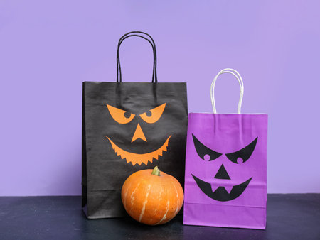 Shopping bags and pumpkins on color background. halloween celebration conceptの写真素材